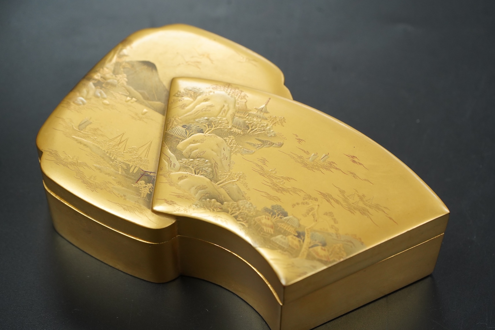 A Japanese gilt lacquer box depicting a mountainous landscape, 13.5cm wide
